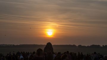 Revellers watch the sunrise as they celebrate the pagan festival of Summer Solstice at Stonehenge in Wiltshire, southern England on June 21, 2017.
The festival, which dates back thousands of years, celebrates the longest day of the year when the sun is at its maximum elevation. Modern druids and people gather at the landmark Stonehenge every year to see the sun rise on the first morning of summer. / AFP PHOTO / CHRIS J RATCLIFFE        (Photo credit should read CHRIS J RATCLIFFE/AFP/Getty Images)