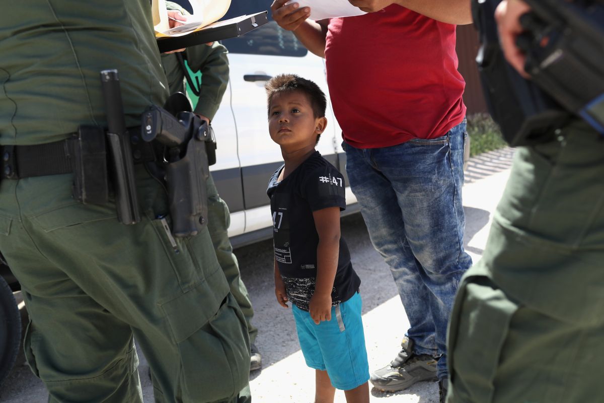 Un niño y su padre, originarios de Honduras, durante la petición de asilo a agentes fronterizos. / FOTO: John Moore/Getty Images