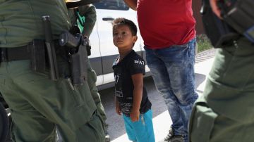 Un niño y su padre, originarios de Honduras, durante la petición de asilo a agentes fronterizos. / FOTO: John Moore/Getty Images
