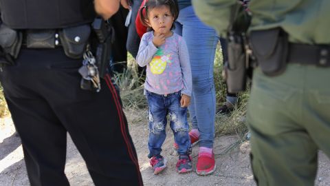 MCALLEN, TX - JUNE 12:  A Mission Police Dept. officer (L), and a U.S. Border Patrol agent watch over a group of Central American asylum seekers before taking them into custody on June 12, 2018 near McAllen, Texas. Local police officers often coordinate with Border Patrol agents in the apprehension of undocumented immigrants near the border. The immigrant families were then sent to a U.S. Customs and Border Protection (CBP) processing center for possible separation. U.S. border authorities are executing the Trump administration's "zero tolerance" policy towards undocumented immigrants. U.S. Attorney General Jeff Sessions also said that domestic and gang violence in immigrants' country of origin would no longer qualify them for political asylum status.  (Photo by John Moore/Getty Images)