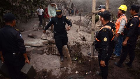 Agentes de policía trabajan en el pueblo El Rodeo, departamento de Escuintla, después de la erupción del volcán.