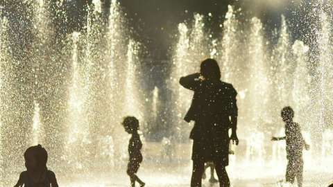 Niños juegan con agua para combatir el calor en Montreal.