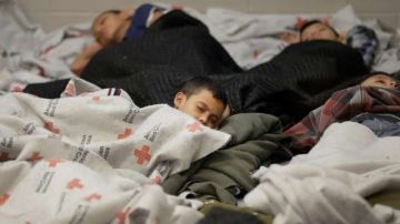 Niños migrantes duermen en un albergue temporal.