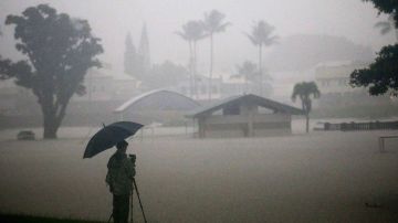 Un hombre toma fotos de las inundaciones en Hilo, Hawaii.