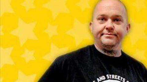 Edward Rackley con su premio de la lotería.