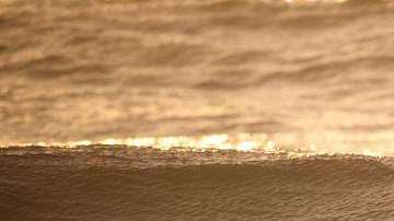 Un hombre surfea las olas en el Océano Atlántico en la playa Wrightsville en Carolina del Norte, estado que espera el azote de Florence.