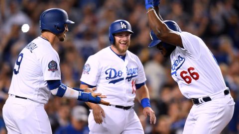 Yasiel Puig festeja su jonrón con Grandal (izq.) y Muncy en el home.