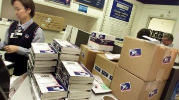 Un trabajador en una oficina de Correos de Lincoln Heights, en Los Ángeles. Para frenar una crisis económica. el Servicio Postal (USPS) ha cerrado y hasta vendido algunas de sus oficinas en todo el país.