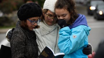 Tres mujeres rezan a una cuadra de la sinagoga Tree of Life tras el atentado de 2018.