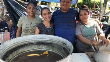 Karla Montes (tercera de d a i) con amigos mexicanos dando comida a migrantes..