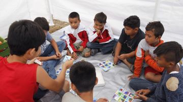 Niños de la caravana de migrantes juegan en refugio en Ciudad México.