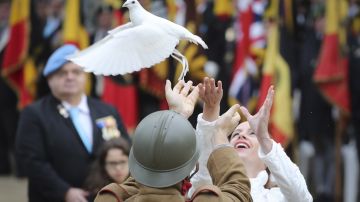 Dos personas lanzan una paloma durante una ceremonia en conmemoración del centenario del Armisticio de la Primera Guerra Mundial.
