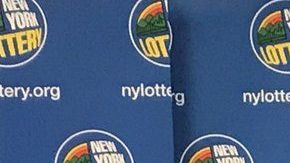 Los tres ganadores con sus cheques ceremoniales de lotería.