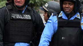 Una manifestante se acuesta frente a la policía en una protesta en Honduras.