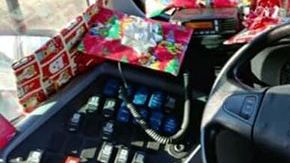 Conductor de autobús regala juguetes a los niños.