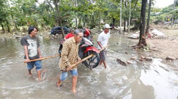 Vecinos limpian las áreas devastadas por el tsunami en Sunda Strait.