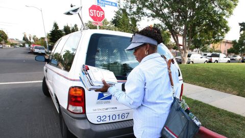 Una empleada postal entrega correo en el sur de Los Ángeles.