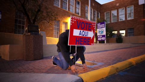 Albert López, voluntario de 18 años, coloca un cartel en la víspera del día electoral del 6 de noviembre.