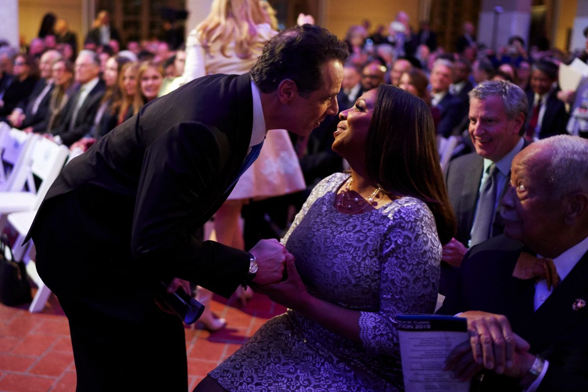 Cuomo saluda a Letitia James, observados por el alcalde Bill de Blasio en Ellis Island, 2019.