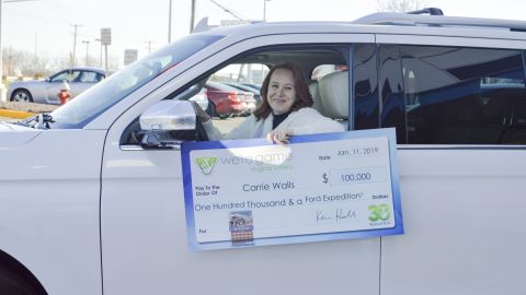 Carrie Walls muestra los dos premios: un auto y $100 mil dólares.