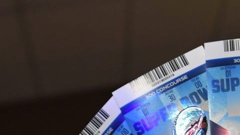 El abogado de la NFL Michael Buchwald sostiene en su mano boletos falsos para el Super Bowl LIII.