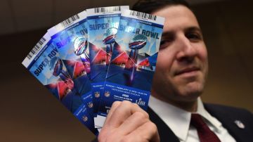 El abogado de la NFL Michael Buchwald sostiene en su mano boletos falsos para el Super Bowl LIII.