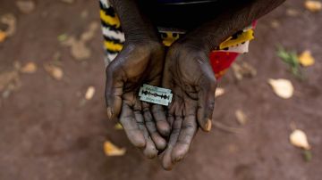 Una mujer de Mombasa, Kenia, conocida como una "mutiladora" , muestra la hojilla de afeitar que usa en los genitales de niñas.