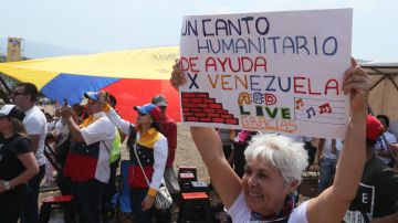 Una mujer sostiene un cartel durante el concierto Venezuela Aid Live, en el puente fronterizo de Tienditas, en Cúcuta (Colombia).