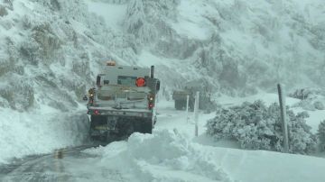 Trabajadores se encuentran despejando la nieve en la zona de las montañas de Chilao en la autopista Crest de Los Ángeles.