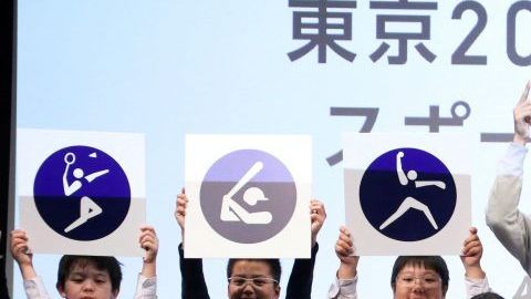 Atletas y estudiantes japoneses exhiben los pictogramas deportivos de Tokio 2020.