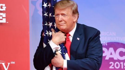 Trump abraza la bandera durante un acto político en Maryland.