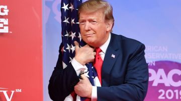 Trump abraza la bandera durante un acto político en Maryland.