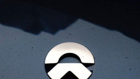 NIO (su logo a la izda) es conocida como el "rival chino de Tesla" (dcha).