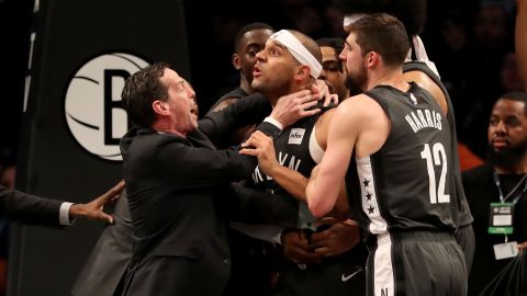 El técnico Kenny Atkinson trata de frenar a su jugador Jared Dudley durante una trifulca con los Sixers.