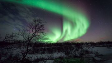 La aurora boreal es causada por ondas de partículas emitidas por el Sol.