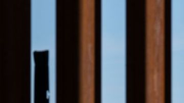 Un globo satírico de un bebé del presidente de los Estados Unidos, Donald Trump, es visto a través de la valla fronteriza entre Estados Unidos y México durante una manifestación contra él durante su visita a Calexico.