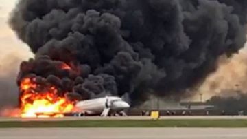 El avión en la pista mientras personas evacuan.