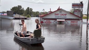 Residentes de Missouri usan un bote para regresar a casa.