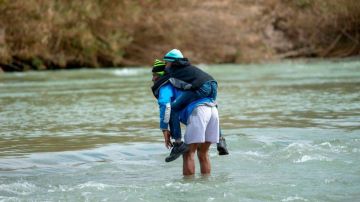 Familias de migrantes con niños cruzan cada día el Río Bravo.