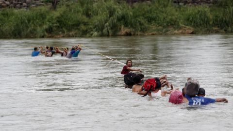 Migrantes hondureños cruzan a pie el río Suchiate, que separa a Guatemala de México.