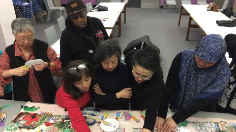 Amigos de la Biblioteca Pública New Utrecht, en Brooklyn, trabajan en la elaboración de un mural artístico que destaca elementos importantes de la comunidad. El mural fue develado en 2018.