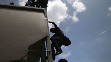 Migrantes cruzan México clandestinamente a bordo de 'La Bestia'.