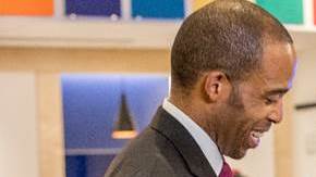 La artista de Harlem  Sandra Spannan muestra a Reggie Chambers, der Chase Consumer Bank, un retrato de él mismo que está en el mural de la sucursal./Cortesía