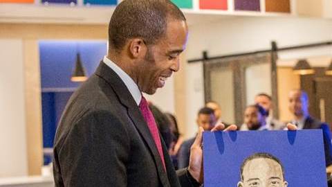 La artista de Harlem  Sandra Spannan muestra a Reggie Chambers, der Chase Consumer Bank, un retrato de él mismo que está en el mural de la sucursal./Cortesía