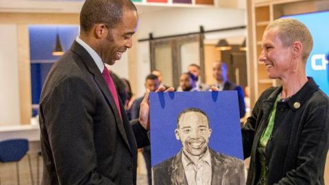 La artista de Harlem  Sandra Spannan muestra a Reggie Chambers, der Chase Consumer Bank, un retrato de él mismo que está en el mural de la sucursal./Cortesía