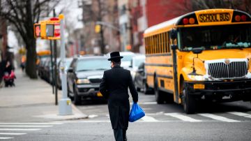A Jewish man crosses a street in a Jewish quarter in Williamsburg Brooklyn on April 9, 2019 in New York City. - New York Mayor Bill de Blasio declared a public health emergency across part of Brooklyn, ordering all residents receive the measles vaccine in a bid to contain an outbreak of the disease. In New York, an Orthodox Jewish community in Brooklyn has been hardest hit. They were infected by visitors from Israel, where an outbreak of measles began a year ago. (Photo by Johannes EISELE / AFP)        (Photo credit should read JOHANNES EISELE/AFP/Getty Images)