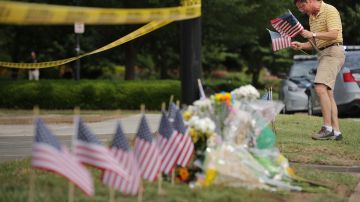 Rich Lindgren coloca 12 banderas en un memorial por los fallecidos.