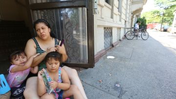 Marelis Sanchez con sus hijos en la puerta de su casa. Miles de usuarios de Con Edison se quedaron sin luz por explosiones en las bocas de calle.