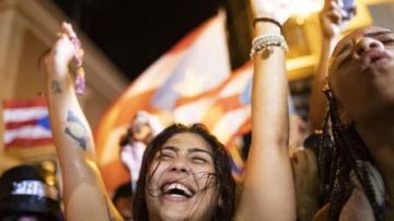 Una joven celebra la salida del gobernador de Puerto Rico, Ricardo Rosselló, en el exterior de La Fortaleza.