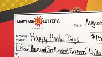 "Happy Honda Days" sostiene el cheque de su premio de lotería.